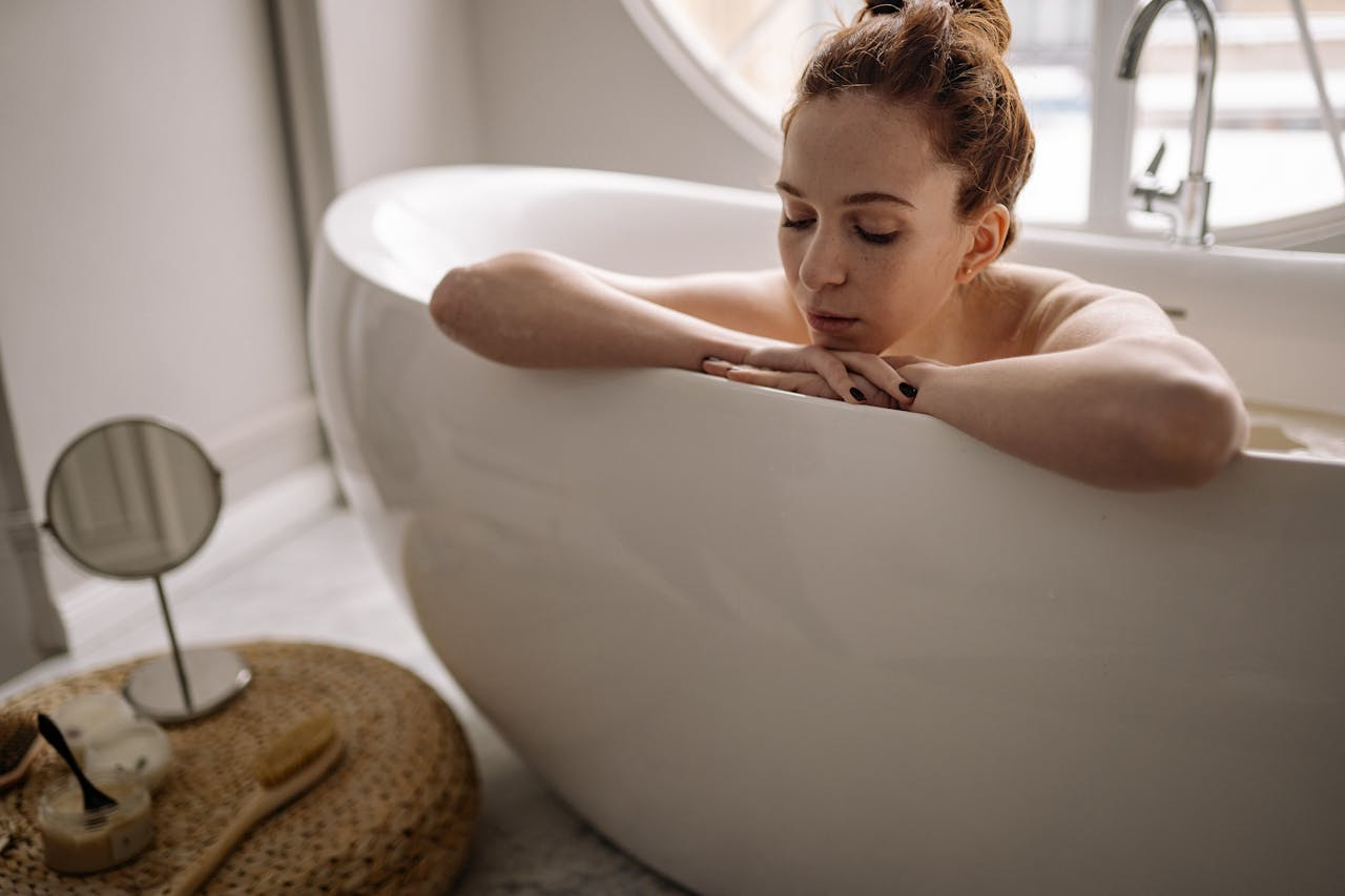 Woman enjoying a serene bath, focusing on relaxation and self-care at home.